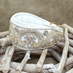 Puede incluir: Collar de perro de cuero blanco con bordados dorados y plateados y pedrería. El collar tiene un diseño de cachemira.