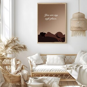 May include: A minimalist art print with a brown background and a silhouette of a person lying down. The text "You are my safe place." is printed in white on the print.