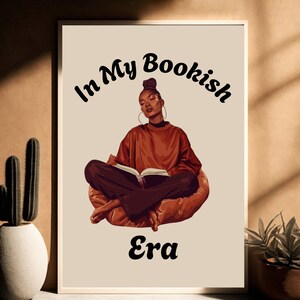 Op de afbeelding: Een digitale illustratie van een vrouw die op een stoel zit en een boek leest. De tekst "In My Bookish Era" staat in een gestileerd lettertype boven haar hoofd.
