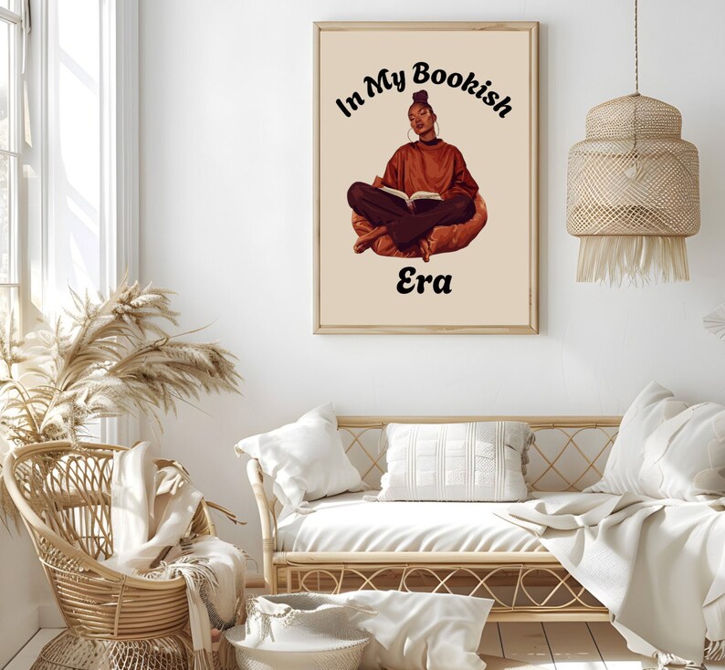 Op de afbeelding: Een digitale illustratie van een vrouw die in kleermakerszit zit en een boek leest. De tekst "In My Bookish Era" staat boven haar.