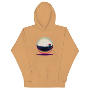 May include: A tan hoodie with a colorful graphic of a sphere with a sunset and ocean inside. The sphere is casting a shadow on the front of the hoodie.
