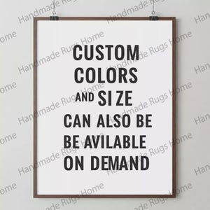 May include: A framed print with the text "CUSTOM COLORS AND SIZE CAN ALSO BE AVAILABLE ON DEMAND" in bold black letters. The print is in a brown frame and is held by two black clips at the top.