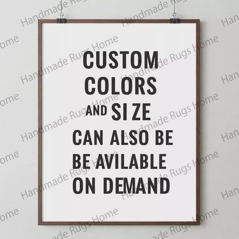 May include: A framed print with the text "CUSTOM COLORS AND SIZE CAN ALSO BE AVAILABLE ON DEMAND" in bold black letters. The print is in a brown frame and is held by two black clips at the top.