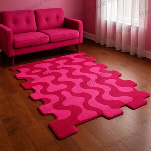 May include: A pink and fuchsia puzzle rug with a wavy pattern. The rug is made of soft, plush material and is perfect for a child's playroom.