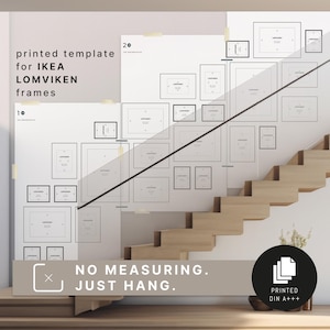 Op de afbeelding: Een afgedrukte sjabloon voor IKEA LOMVIKEN-frames wordt getoond op een witte muur. De sjabloon bevat contouren van verschillende frameformaten, met de tekst "NO MEASURING. JUST HANG." en "PRINTED DIN A+++." De afbeelding toont een trap.