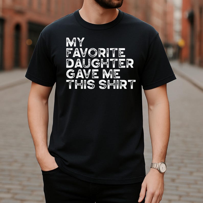 Pu&ograve; includere: T-shirt nero girocollo con la scritta bianca "MY FAVORITE DAUGHTER GAVE ME THIS SHIRT". La maglietta &egrave; realizzata in un materiale morbido ed &egrave; adatta per l'abbigliamento casual.