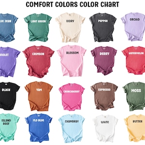 K&ouml;nnte beinhalten: Eine Comfort Colors Farbkarte mit zwanzig kurz&auml;rmeligen T-Shirts in verschiedenen Farben, darunter Blue Jean, Light Green, Ivory, Pepper, Orchid, Violet, Crimson, Blossom, Berry, Watermelon, Black, Yam, Crunchberry, Espresso, Moss, Island Reef, Flo Blue, Chambray, White und Butter.