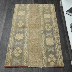 May include: A beige and gray patterned runner rug with a subtle floral design. The rug has a distressed look and is made of a woven material.