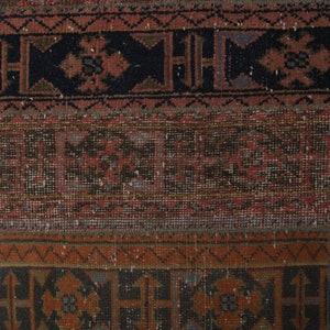 May include: A vintage rug with a geometric pattern in shades of red, brown, and black. The rug has a worn and faded look, giving it a rustic and antique feel.