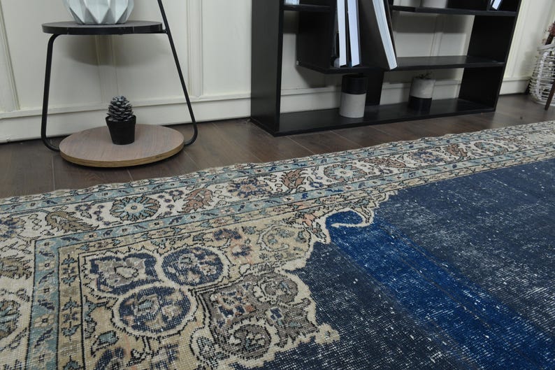 May include: A vintage rug with a faded blue and cream color scheme. The rug has a traditional Persian design with intricate floral patterns.