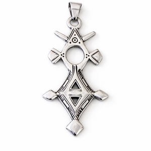 May include: Silver-toned pendant with a geometric design. The pendant features a central diamond shape with a smaller triangle inside, surrounded by other geometric shapes and a circular opening. It has a loop at the top for a chain.