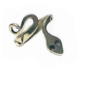 May include: A silver-coloured snake ring with a coiled tail and a head featuring two eye holes. The ring is set against a white background, highlighting its detailed design and metallic finish. A unique piece of jewellery.