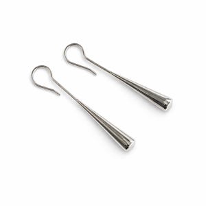 Może przedstawiać: Para srebrnych kolczyków w kształcie łezki. Każdy kolczyk ma długi, smukły, stożkowy korpus z zaokrąglonym końcem i zakrzywionym haczykiem do ucha. Kolczyki są prezentowane na białym tle.