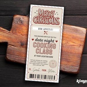 May include: A Christmas-themed gift voucher for a date night cooking class. The voucher, with a cream background and red text, is placed on a wooden cutting board. The text reads "Merry Christmas" and "Bon Appétit!"