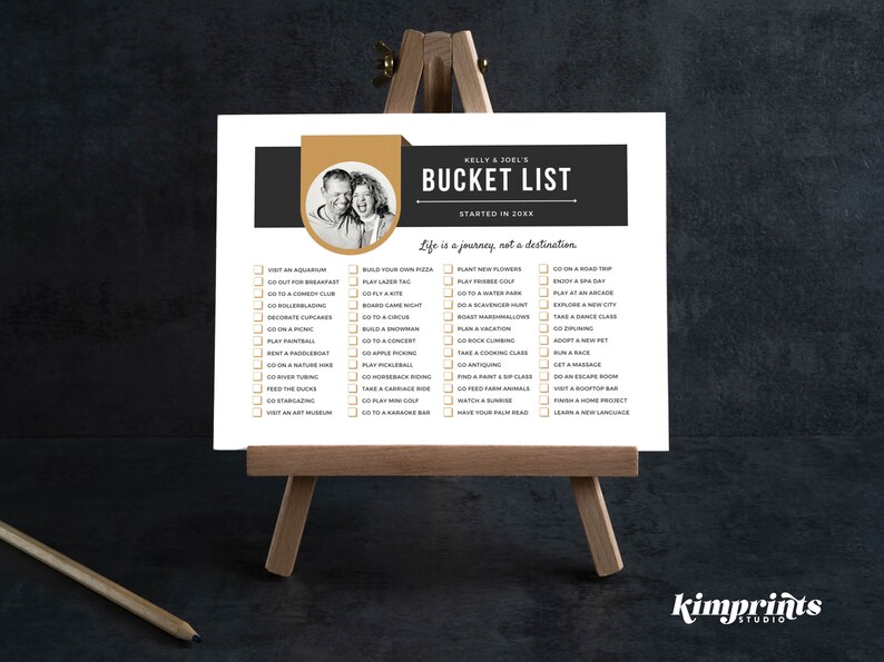 Op de afbeelding: Een afdrukbare bucketlist met een zwart en gouden ontwerp. De lijst heeft de titel "Kelly & Joel's Bucket List" en bevat een foto van een stel. De lijst bevat activiteiten zoals "Bezoek een aquarium", "Ga naar een comedyclub", "Plant nieuwe bloemen", "Ga op een roadtrip" en "Leer een nieuwe taal".