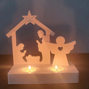 Può includere: Portacandele natalizio in legno bianco a forma di scena della natività con due tealight. La scena rappresenta una stella, un angelo, Maria, Giuseppe e Gesù bambino.