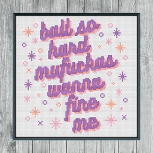 以下が含まれることがあります： 「ball so hard mufuckas wanna fine me」の文字が紫色の桃色の影で描かれた額入りのクロスステッチアート。背景は白で、ピンクとオレンジのスターバーストアクセントが付いています。