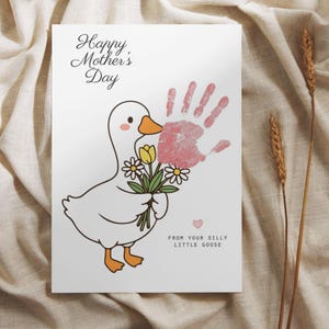 May include: A white card with a cartoon goose holding flowers and a pink handprint. The card reads "Happy Mother's Day" and "From your silly little goose."