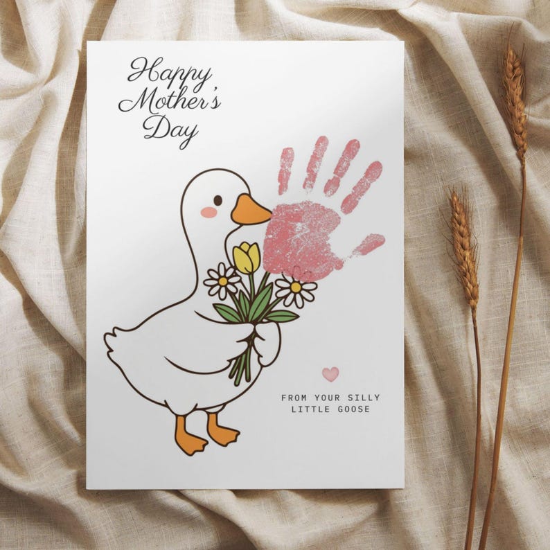 May include: A white card with a cartoon goose holding flowers and a pink handprint. The card reads "Happy Mother's Day" and "From your silly little goose."