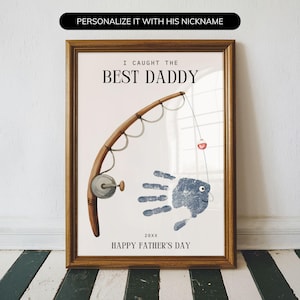 May include: A framed wall art print featuring a brown fishing rod and a blue handprint shaped like a fish. The text reads I CAUGHT THE BEST DADDY, 20XX, and HAPPY FATHER'S DAY. The design includes a fishing line with a small red and white bobber.
