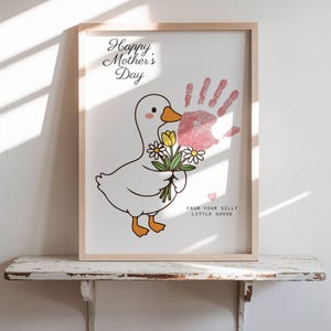 May include: A framed print for Mother's Day featuring a cartoon goose holding flowers. The print includes a pink handprint and the text "Happy Mother's Day" and "From Your Silly Little Goose."