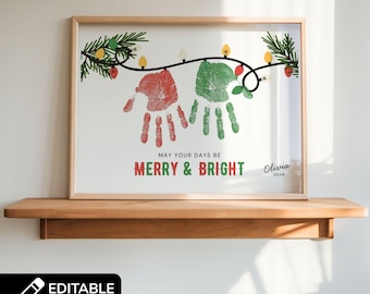 May include: Framed Christmas artwork featuring red and green handprints, festive lights, and the text "MERRY & BRIGHT." The artwork includes the text "MAY YOUR DAYS BE" and a name and year. The frame is a light wood color.