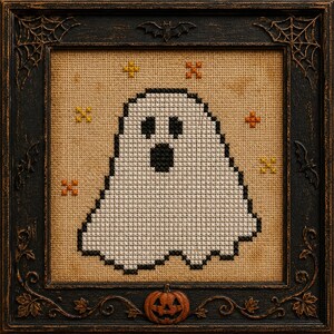 May include: A cross-stitch embroidery featuring a white ghost with black eyes and a black mouth, set against a tan fabric background. Small orange and yellow cross-stitched stars surround the ghost. The piece is encased in a black frame.