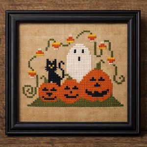 Puede incluir: Diseño de Halloween en punto de cruz en un marco negro. La obra de arte presenta un gato negro, un fantasma blanco y tres calabazas naranjas. En la parte superior, hay vides verdes con caramelos de maíz. El fondo es de tela color beige.