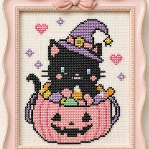 Puede incluir: Punto de cruz de un gato negro con un sombrero de bruja morado, sentado en una calabaza rosa. El gato está rodeado de caramelos de colores. La obra está enmarcada en un marco rosa con un lazo, ideal para la decoración de Halloween.