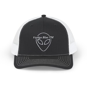 Può includere: Cappellino da camionista nero e bianco con una grafica aliena bianca e il testo "Vertigo Blue TM" ricamato sul davanti.