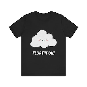 May include: Black t-shirt featuring a white cartoon cloud with a smiling face and the text "FLOATIN' ON!"
