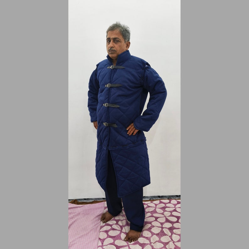 May include: A long, navy blue quilted jacket with a stand-up collar and multiple buckles down the front.