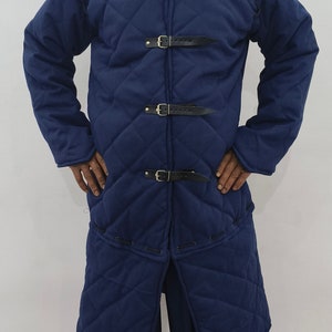 May include: A blue quilted jacket with a long length and multiple buckles. The jacket is made of a thick, durable fabric and has a classic design.