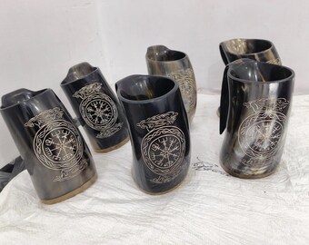 May include: Six black and brown drinking horns with a silver trim. Each horn has a design of a compass with a knotwork pattern around it.