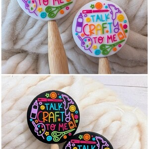 May include: Two white and two black circular toppers featuring the text TALK CRAFTY TO ME in colorful letters. The designs include illustrations of scissors, glue guns, paint palettes, and buttons in bright neon colors, each attached to a wooden handle.