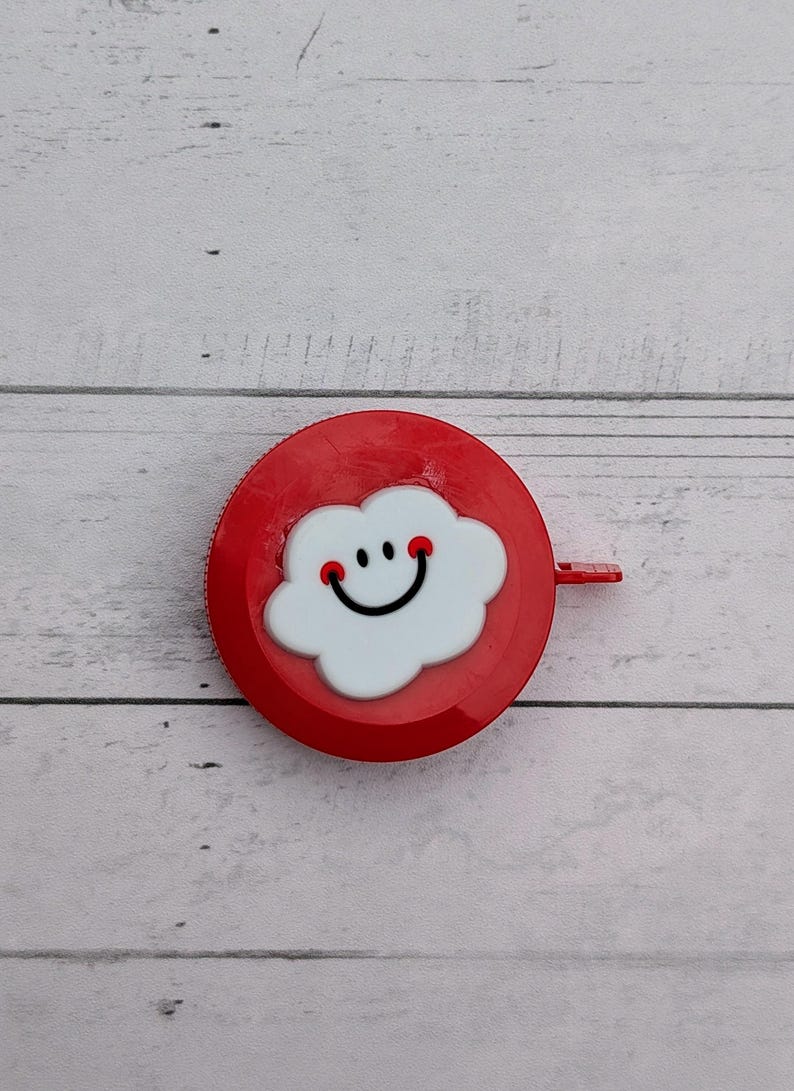 Puede incluir: Un bot&oacute;n redondo rojo con una nube blanca con una cara sonriente.