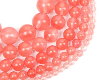 May include: Close-up of several strands of coral-colored gemstone beads. The beads vary in size, ranging from large, round beads to smaller, more delicate ones. The beads have a smooth, polished surface and a translucent quality.