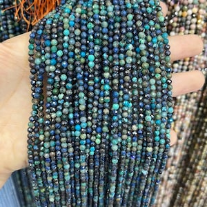 May include: A strand of blue and green gemstone beads. The beads are faceted and have a speckled appearance.