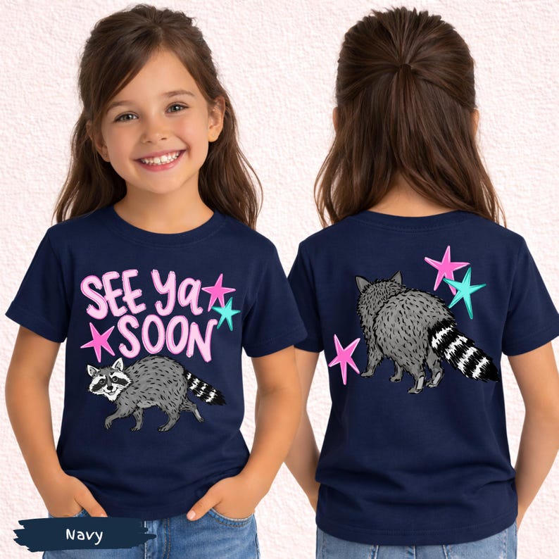 May include: Navy blue t-shirt featuring a raccoon illustration and the text "SEE Ya SOON" in pink and teal. The back of the shirt also displays a raccoon and stars.