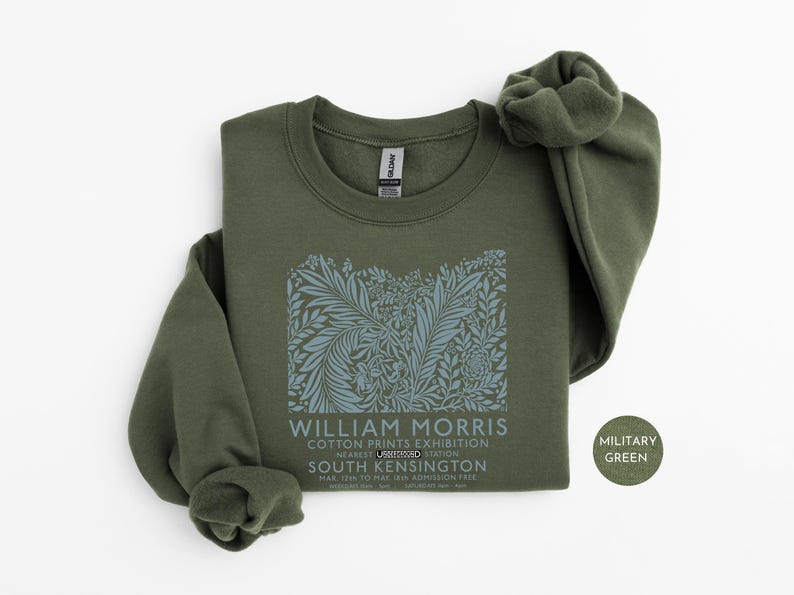 Puede incluir: Sudadera verde militar con un dise&ntilde;o floral y el texto "WILLIAM MORRIS COTTON PRINTS EXHIBITION". La sudadera tiene cuello redondo y mangas largas. El texto tambi&eacute;n incluye "SOUTH KENSINGTON".