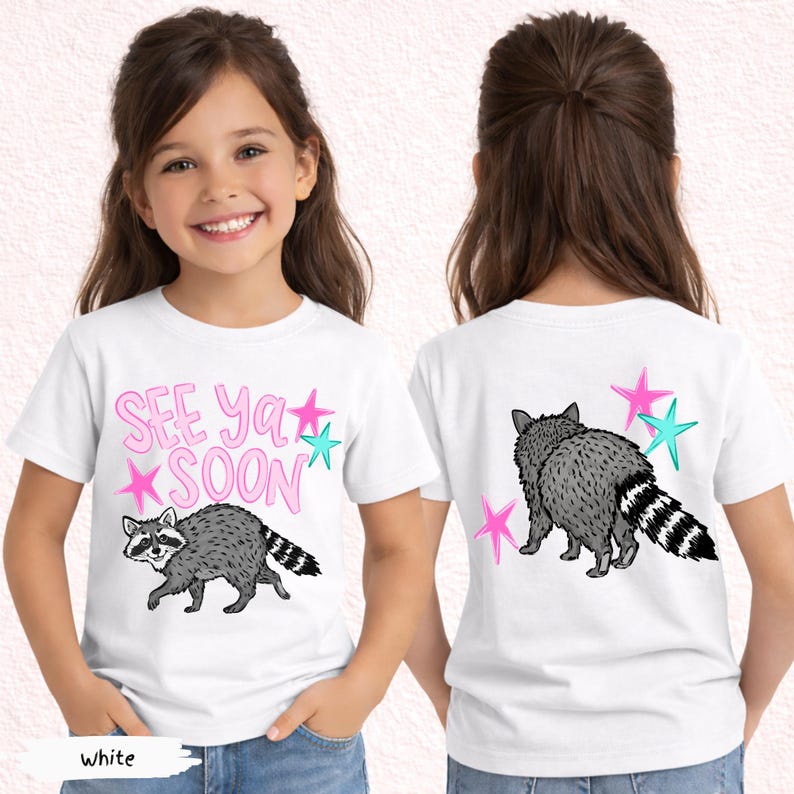 May include: White t-shirt featuring a raccoon illustration with the text "SEE Ya SOON" in pink. The raccoon is gray and black with a striped tail. Pink and teal stars are also on the shirt. The back of the shirt also has a raccoon and stars.