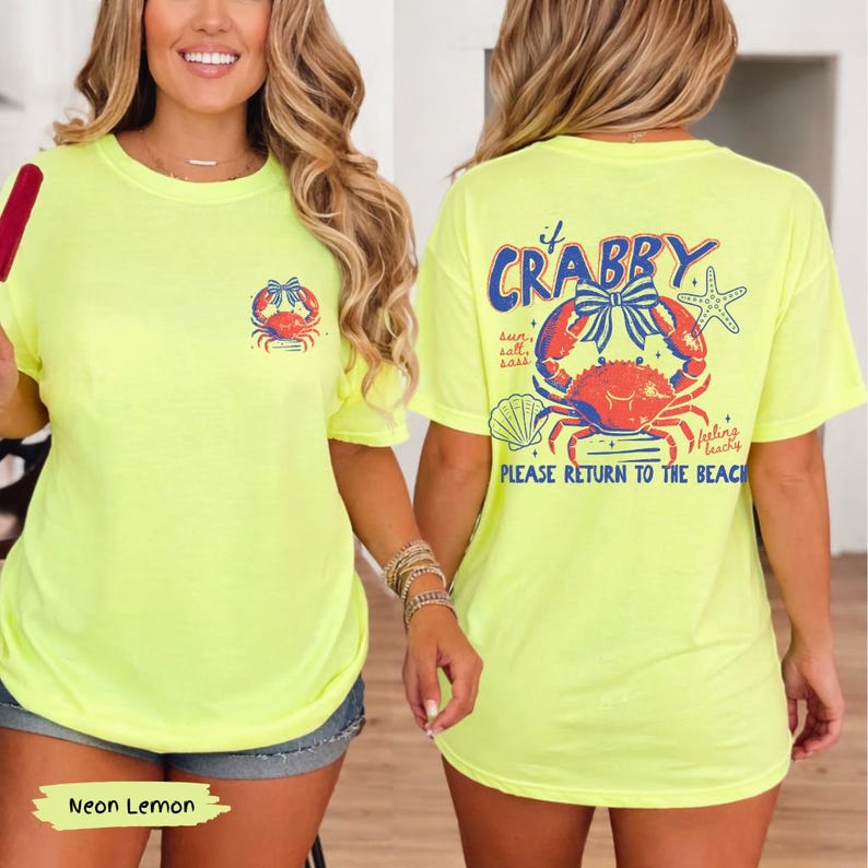 Puede incluir: Camiseta de color amarillo ne&oacute;n con un dise&ntilde;o de cangrejo en la parte delantera y trasera. El dise&ntilde;o trasero dice "Crabby" con un cangrejo, una estrella de mar y una concha. El texto en la parte posterior dice "Please Return to the Beach."