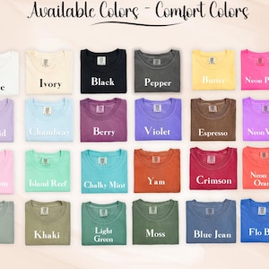 Puede incluir: Una exhibici&oacute;n de camisetas dobladas en varios colores, incluyendo blanco, negro y azul. El texto "Available Colors - Comfort Colors" est&aacute; en la parte superior. Cada camiseta est&aacute; etiquetada con su nombre de color, como "Orchid" y "Crimson".