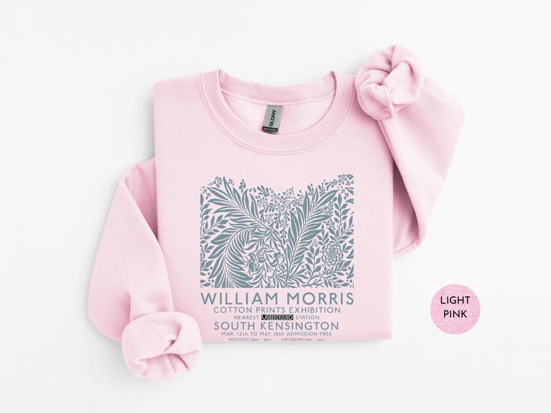 Puede incluir: Sudadera rosa claro con un dise&ntilde;o floral gris y el texto "WILLIAM MORRIS COTTON PRINTS EXHIBITION SOUTH KENSINGTON". El dise&ntilde;o incluye elementos bot&aacute;nicos y texto. La sudadera es de color rosa claro.