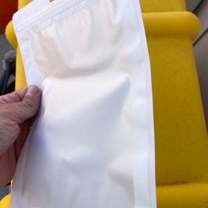 Puede incluir: Una bolsa de pl&aacute;stico blanca con cierre herm&eacute;tico y una ventana transparente. La bolsa tiene un agujero para colgar en la parte superior.