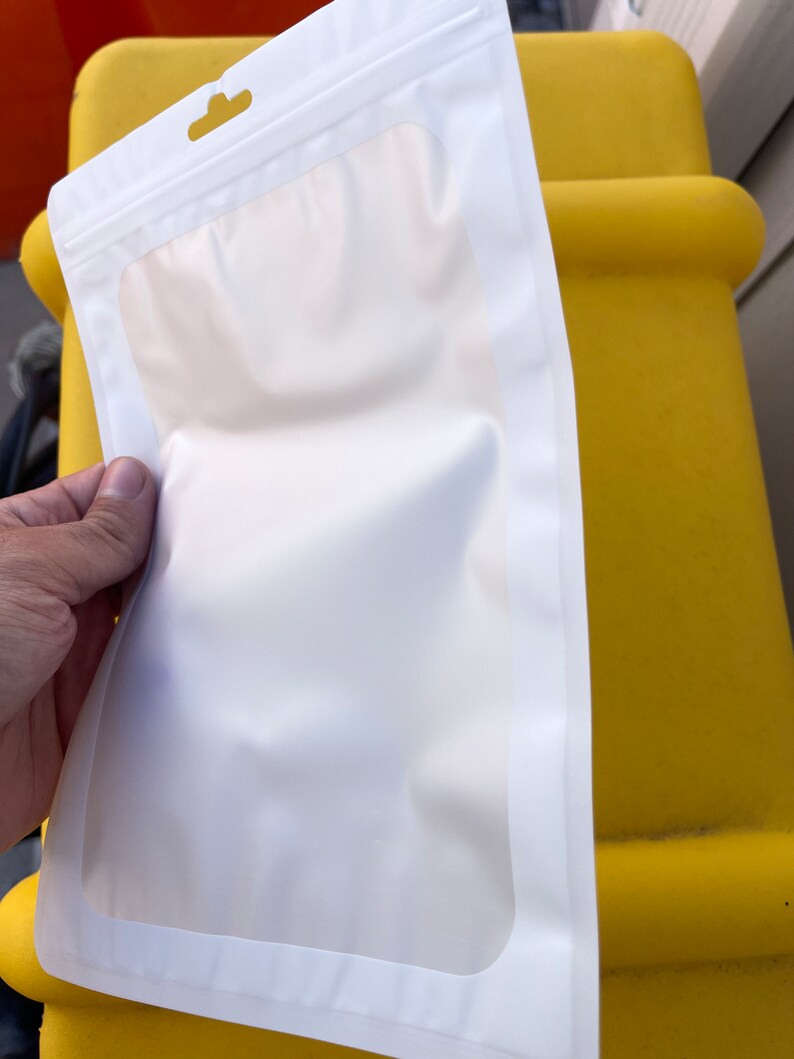 Puede incluir: Una bolsa de pl&aacute;stico blanca con cierre herm&eacute;tico y una ventana transparente. La bolsa tiene un agujero para colgar en la parte superior.