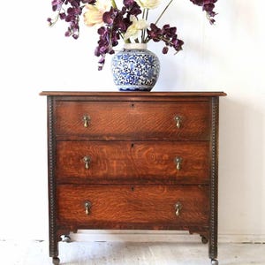 Antique Oak Chest of Drawers on Castors with Brass Handles and Carved Details
