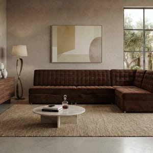 May include: A dark brown tufted sectional sofa with a chaise lounge, positioned in a room with a round white marble coffee table, a wooden sideboard with ceramic vases, a tall floor lamp, and a large abstract wall art piece in neutral tones.
