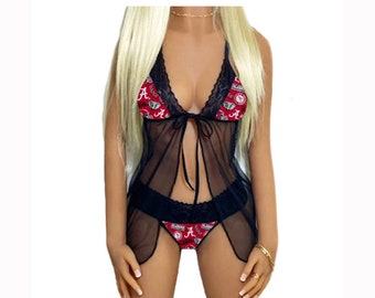 May include: Black lingerie set with a sheer, flowing design. The bra and panty feature a red and white pattern with the word "Alabama" and the letter "A". The set includes a matching sheer cover-up.