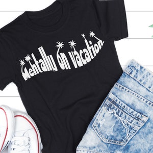 Puede incluir: Camiseta negra con texto blanco que dice "Mentally on Vacation" con gr&aacute;ficos de palmeras. La camiseta est&aacute; colocada sobre una superficie blanca con un par de zapatillas blancas y unos vaqueros azules.